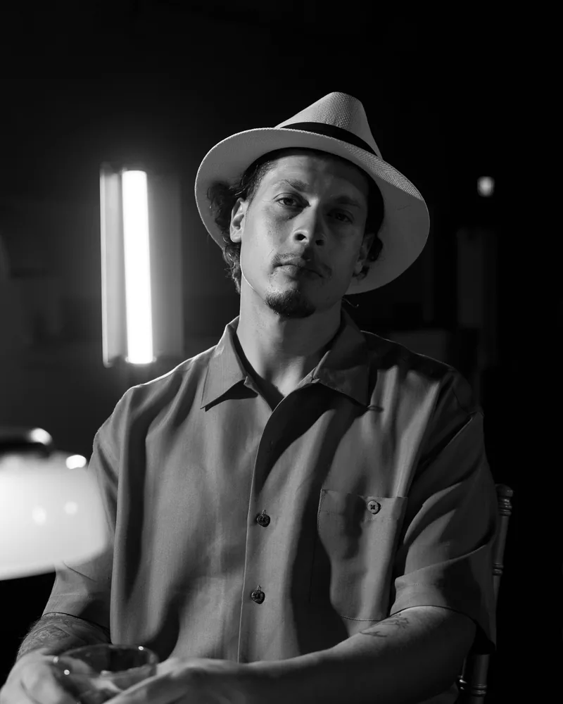 Dan Perales in a straw fedora, black-and-white portrait