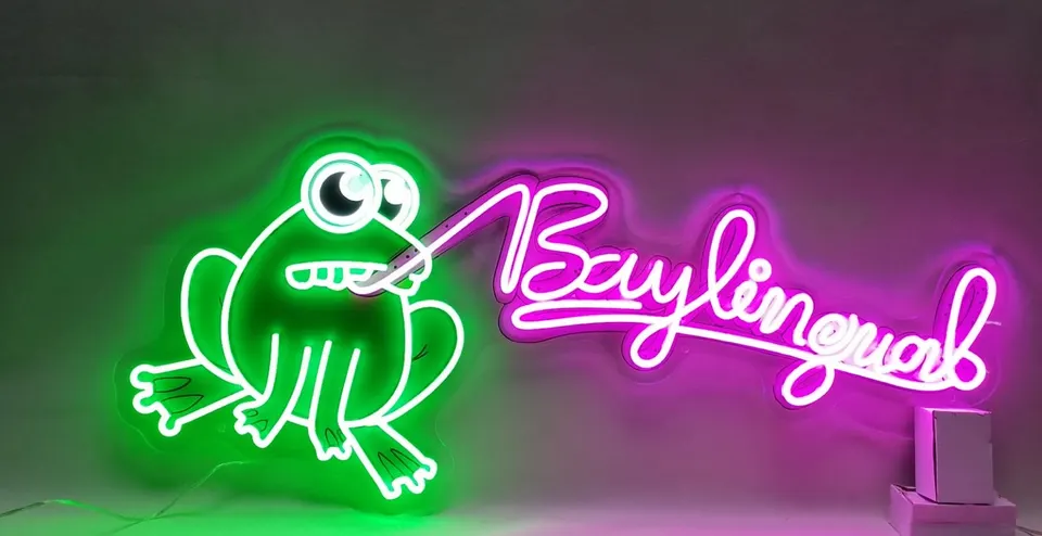 Baylingual neon sign, lit: a green frog and pink script