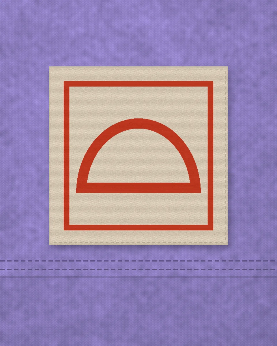 Close-up of the square woven label with the red croissant mark, sewn above a tee's hem